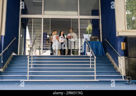Young students walking out of university after classes discussing subject Stock Photo