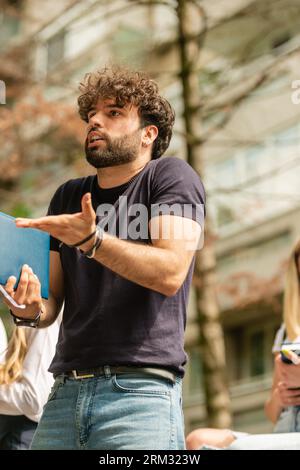 Upset male student arguing with his colleague outside while taking a break from classes at school Stock Photo