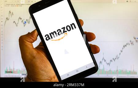 Sao Paulo, Brazil, august 25, 2023. Amazon logo is seen on an smartphone over stock chart background in Brazil Stock Photo