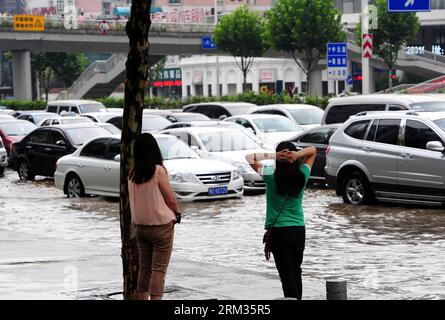 Bildnummer: 60030379  Datum: 07.07.2013  Copyright: imago/Xinhua watch cars driving on a flooded road in Wuchang District of Wuhan, capital of central China s Hubei Province, July 7, 2013. Wuhan was hit by the heaviest rainstorm in five years from Saturday to Sunday. The local meteorologic center has issued red alert for rainstorm for many times in sequence. (Xinhua/Xiao Yijiu) (zwx) CHINA-HUBEI-WUHAN-RAINSTORM(CN) PUBLICATIONxNOTxINxCHN Gesellschaft Hochwasser Unwetter Regen Überschwemmung xas x0x 2013 quer     60030379 Date 07 07 2013 Copyright Imago XINHUA Watch Cars Driving ON a flooded Ro Stock Photo