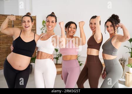 Portrait group five beautiful sporty women posing smiling and empowered for photo.  Stock Photo