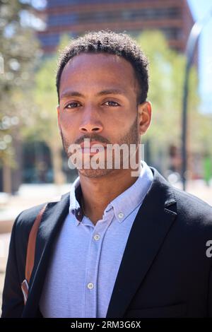 Vertical portrait of young adult Latino business man with serious expression. Commercial male formal Stock Photo