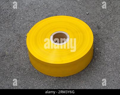 Yellow safety roll tape standing outside on the ground Stock Photo