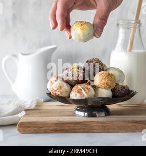 A hand picking up a pumpkin spice truffle from a dessert stand full of them. Stock Photo