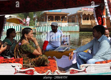 Bildnummer: 60534816  Datum: 27.09.2013  Copyright: imago/Xinhua (130927) -- SRINAGAR, Sept. 27, 2013 (Xinhua) -- A vendor touts souvenir pictures to tourists on Dal lake in Srinagar, the summer capital of Indian-controlled Kashmir, Sept. 27, 2013. Dal lake, the biggest lake and the most popular tourist destination of Srinagar, is the place where many local live on. They live in the houses built on the islands and houseboats floating on the water in the lake and take boats for daily commutation. Shops, houses and gardens dot the lake. Thanks to the mild weather and scenery, tourism became the Stock Photo