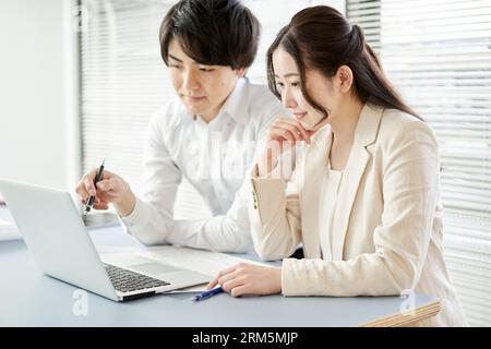 Asian architect having a meeting by looking at a computer Stock Photo