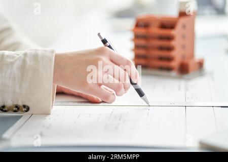 At the hands of a female architect who designs an apartment Stock Photo