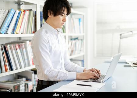 Male construction management engineer who organizes materials on a laptop computer Stock Photo