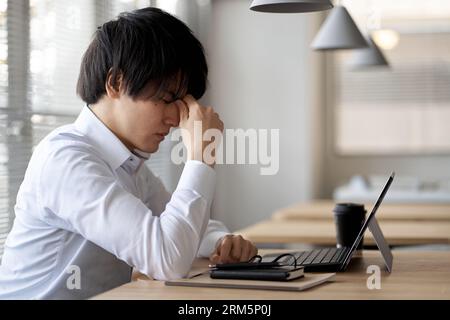 Asian businessman tired of computer work Stock Photo