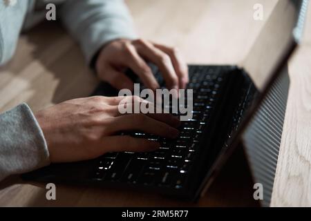 Male hacker hitting text on a laptop Stock Photo