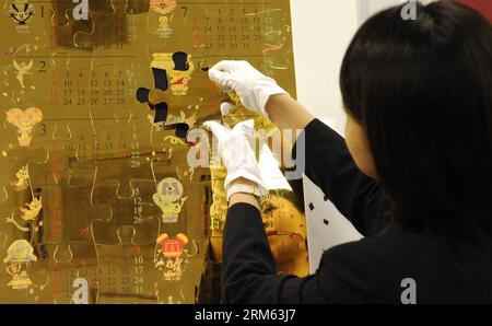 Bildnummer: 60787016  Datum: 03.12.2013  Copyright: imago/Xinhua     (131203) -- TOKYO, Dec. 3, 2013 (Xinhua) -- A Japan s jewelry shop Ginza Tanaka s employee puts togeter puzzles of Disney Pure Gold Big Calender in Tokyo, Japan, Dec. 3, 2013. Disney Pure Gold Big Calender is made of 54 puzzle pieces (10 kilogram pure gold). Ginza Tanaka sells at a price of 100,000,000 JPY(around 1,013,880 US dollars). (Xinhua) JAPAN-TOKYO-GOLD CALENDER PUBLICATIONxNOTxINxCHN Wirtschaft Kalender premiumd x0x xsk 2013 quer Stock Photo