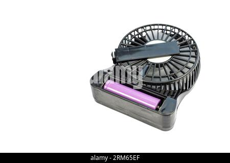 Portable USB rechargeable small fan with battery lid open laying on isolated white background Stock Photo