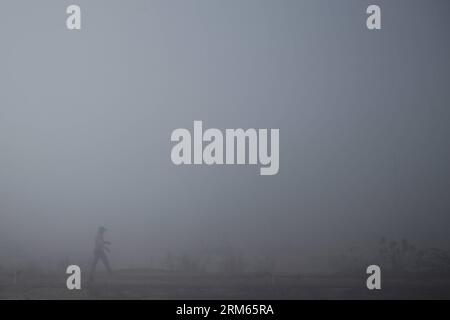 Bildnummer: 60812711  Datum: 10.12.2013  Copyright: imago/Xinhua     (131210) -- HARYANA, Dec. 10, 2013 (Xinhua) -- A man walks on a foggy day in a village near the city of Jind, Haryana, India, Dec. 10, 2013. Heavy fog cloaked many places in north India s states of Haryana and Punjab, with visibility less then 200 meters in some areas, affecting public transportation and local people s life. (Xinhua/Zheng Huansong) INDIA-HARYANA-PUNJAB-FOG PUBLICATIONxNOTxINxCHN Gesellschaft x2x xkg 2013 quer  o0 Nebel Wetter Sicht Sichtverhältnisse, Straße Verkehr Stock Photo