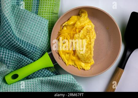 Omelette with cheese folded in pan - top view photo Stock Photo