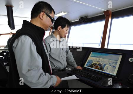 (131228) -- ABOARD XUELONG, Dec. 28, 2013 (Xinhua) -- Liu Shunlin (L), chief scientist and leader of the team, and Wang Jianzhong, captain of Xuelong, studies the condition of a trapped Russian science ship on Chinese icebreaker Xuelong, or Snow Dragon, Dec. 28, 2013. Chinese icebreaker Xuelong, or Snow Dragon, on way to rescue a Russian science ship trapped off Antarctica, has stalled itself since midnight Friday after getting stuck in thick ice only 6.1 nautical miles away from the Russian ship. (Xinhua/Zhang Jiansong) (yxb) CHINA-30TH ANTARCTIC EXPEDITION-ICEBREAKER (CN) PUBLICATIONxNOTxINx Stock Photo