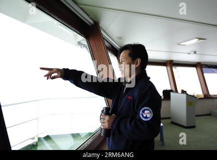 (131228) -- ABOARD XUELONG, Dec. 28, 2013 (Xinhua) -- Wang Jianzhong, captain of Xuelong, observes the weather condition on Chinese icebreaker Xuelong, or Snow Dragon, Dec. 28, 2013. Chinese icebreaker Xuelong, or Snow Dragon, on way to rescue a Russian science ship trapped off Antarctica, has stalled itself since midnight Friday after getting stuck in thick ice only 6.1 nautical miles away from the Russian ship. (Xinhua/Zhang Jiansong) (yxb) CHINA-30TH ANTARCTIC EXPEDITION-ICEBREAKER (CN) PUBLICATIONxNOTxINxCHN   Aboard XUELONG DEC 28 2013 XINHUA Wang Jianzhong Captain of XUELONG observes The Stock Photo