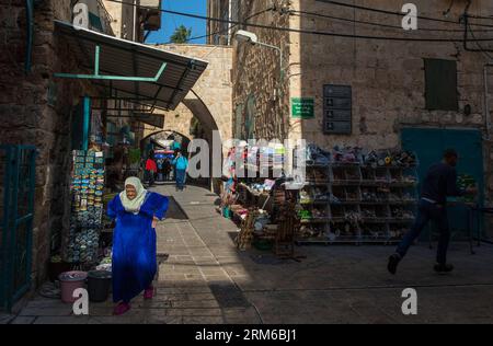 (131231) -- ACRE, Dec. 31, 2013 (Xinhua) -- People walk past an alley in the Old City of Acre, northern Israel, Dec. 27, 2013. The Old City of Acre in Acre in Israel was inscribed on the UNESCO World Heritage List in 2001. With a history of more than 5,000 years recorded in documents, Acre is a walled port-city with continuous settlement from the Phoenician period. The present city is characteristic of a fortified town of the Ottoman dating from 18th and 19th centuries, with typical urban components such as the citadel, mosques, khans and baths. The remains of the Crusader town, dating from 11 Stock Photo