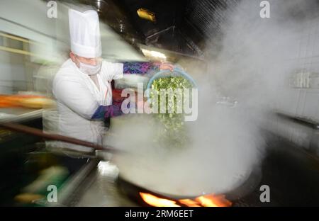 A volunteer makes laba porridge, a kind of rice porridge with nuts and dried fruits, at the Daming Temple in Yangzhou, east China s Jiangsu Province, Jan. 7, 2014. Chinese have the tradition to eat laba porridge on the eighth day of the 12th lunar month, which falls on Jan. 8 this year. (Xinhua/Meng Delong) (ry) CHINA-YANGZHOU-CUSTOM (CN) PUBLICATIONxNOTxINxCHN   a Volunteer makes Laba Porridge a Child of Rice Porridge With Nuts and dried Fruits AT The Daming Temple in Yang Zhou East China S Jiangsu Province Jan 7 2014 Chinese have The Tradition to Eat Laba Porridge ON The Eighth Day of The 12 Stock Photo
