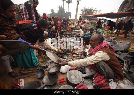 (140116) -- WEST BENGAL, (Xinhua) -- People buy things at the Joydev Kenduli Mela in the village of Kenduli, Joydev in West Bengal State of India, Jan. 15, 2014. The Joydev Kenduli Mela, a three-day grand fair to commemorate India s famous ancient poet Joyadeva who composed the Gita Govinda, was held on Wednesday. Tens of thousands of tourists were attracted to come not only to hear the Bauls who sing the hymns composed by Joyadeva, but also to enjoy the flavour of a typical Indian countryside market, such as snake charmers, street food and so on. (Xinhua/Zheng Huansong) INDIA-WEST BENGAL-JOYD Stock Photo