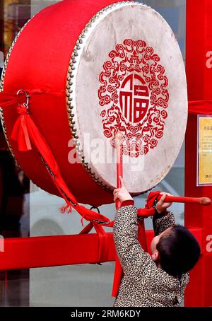 (140118) -- ZHENGZHOU, Jan. 18, 2014 (Xinhua) -- Photo taken on Feb. 2, 2011 shows a boy hitting a drum with the Chinese character fu on it on the street of Zhengzhou, capital of central China s Henan Province. The Chinese Character fu , which means good luck , is common everywhere across China during the Spring Festival. It is popular for its propitious meaning, also can be interpreted as happiness , which the Chinese people believe will give them blessing in the coming new year. (Xinhua/Wang Song) (zwx) CHINA-SPRING FESTIVAL-CHINESE CHARACTER FU (CN) PUBLICATIONxNOTxINxCHN   Zhengzhou Jan 18 Stock Photo