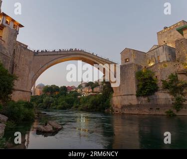 Visitors on Stari Most (Old Bridge) over the Neretva River on a summers evening. Mostar, Bosnia and Herzegovina, August 22, 2023. Stock Photo