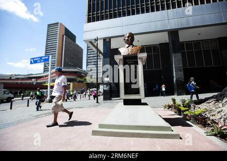 (140122) -- CARACAS, Jan. 22, 2014 (Xinhua) -- People walk pass the bust in honor of the late South African President Nelson Mandela in Pedro Camejo Square of Caracas, Venezuela, on Jan. 22, 2014. Venezuelan Vice President Jorge Arreaza unveiled the bust donated by the South African Embassy in Venezuela. The bust is made of bronze and measures 90 centimeters and was created by the artist Leonel Duran. (Xinhua/Boris Vergara) (ah) (sp) VENEZUELA-CARACAS-BUST-MANDELA PUBLICATIONxNOTxINxCHN   Caracas Jan 22 2014 XINHUA Celebrities Walk Passport The bust in HONOR of The Late South African President Stock Photo