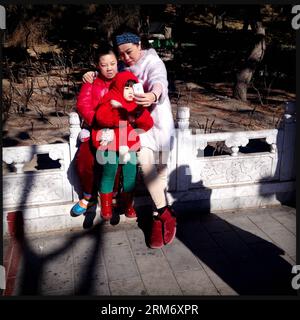 (140203) -- BEIJING, Feb. 3, 2014 (Xinhua) -- In this photo taken with a smartphone on Feb. 3, 2014, tourists take photos of themselves using smartphone at the Changdian Temple Fair in Beijing, capital of China. In Beijing, temple fairs have been a typical repertoire during the Spring Festival, which fell on Jan. 31 this year. People entertain themselves at temple fairs with various food and snacks as well as folk activities. (Xinhua/Shen Bohan) (lmm) CHINA-BEIJING-SPRING FESTIVAL-TEMPLE FAIR-SMARTPHONE (CN) PUBLICATIONxNOTxINxCHN   Beijing Feb 3 2014 XINHUA in This Photo Taken With a Smartpho Stock Photo