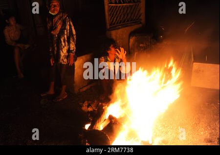 People warm themselves by bonfires at a village in Kediri, Indonesia, Feb. 16, 2014. Locals living around the Kelud volcano in town of Kediri, East Java province affected by the recent eruption Sunday called on government to provide assistance to rebuild their houses that were severely damaged during the eruption. (Xinhua/Veri Sanovri) (srb) INDONESIA-KEDIRI-MOUNT KELUD ERUPTION-AFTERMATH PUBLICATIONxNOTxINxCHN   Celebrities warm themselves by bonfires AT a Village in Kediri Indonesia Feb 16 2014 Locals Living Around The Kelud Volcano in Town of Kediri East Java Province Affected by The Recent Stock Photo