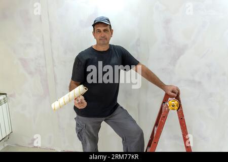 Male builder, master office, plasterer with a tool in working clothes Stock Photo