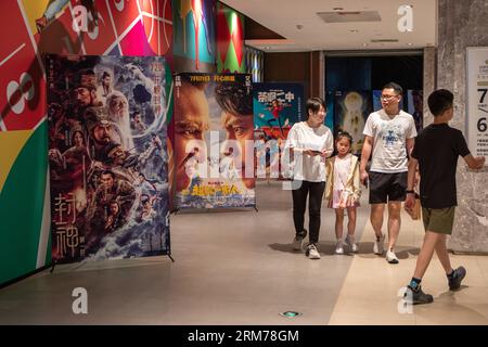 Beijing, China. 30th July, 2023. People walk past film posters outside a cinema in Yubei District of Chongqing, southwest China, July 30, 2023. Credit: Chu Jiayin/Xinhua/Alamy Live News Stock Photo