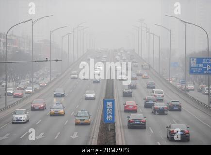 (140220) -- BEIJING, Feb. 20, 2014 (Xinhua) -- Vehicles run on smog-shrouded road in Beijing, capital of China, Feb. 20, 2014. Beijing on Thursday issued a yellow alert for air pollution in the next three days. The city has a four-tier alert system, using blue, yellow, orange and red to indicate the air pollution level in order of increasing severity. (Xinhua/Luo Xiaoguang) (ry) CHINA-BEIJING-AIR POLLUTION (CN) PUBLICATIONxNOTxINxCHN Stock Photo