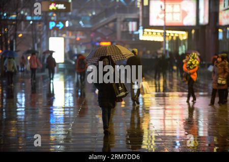 (140226) -- BEIJING, Feb. 26, 2014 (Xinhua) -- A pedestrian walks in the rain in Xidan, a commercial area in Beijing, capital of China, Feb. 26, 2014. Beijing saw its first rain this spring on Wednesday evening. The precipitation would be conducive to the city s air quality, which had been marred by a lingering smog. (Xinhua/Li Xin) (lmm) CHINA-BEIJING-RAIN (CN) PUBLICATIONxNOTxINxCHN   Beijing Feb 26 2014 XINHUA a Pedestrian Walks in The Rain in Xidan a Commercial Area in Beijing Capital of China Feb 26 2014 Beijing SAW its First Rain This Spring ON Wednesday evening The precipitation Would B Stock Photo