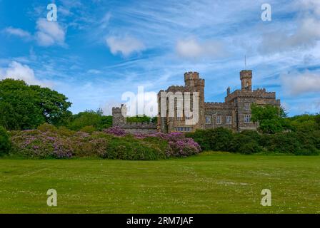Lews Castle at Stornoway in the Hebrides with its Gothic Victorian architecture surrounded by Flowering Rhododendron Bushes and Trees. Stock Photo