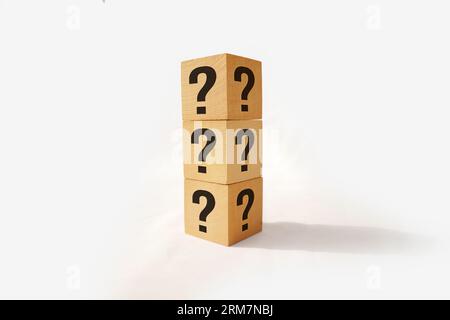 Stack of three wooden cubes with question mark over nature background with sunlight with copy space Stock Photo