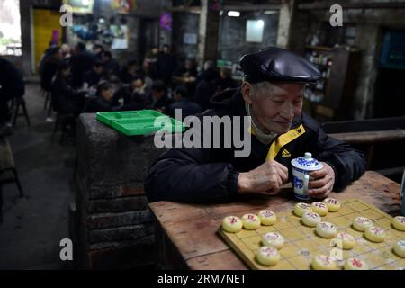 CHONGQING, March 07, 2014 (Xinhua) -- A customer enjoys a cup of tea during a Chinese chess game at the Jiaotong Tea House in Jiulongpo District of southwest China s Chongqing Municipality, March 7, 2014. The Jiaotong Tea House, in business for nearly three decades, has become the favourite place to go for many tea lovers as many other tea houses in downtown Chongqing were closed down. Many customers stay here for a whole day, involved in typical tea house entertainments: savouring tea, chatting with others, playing cards and remembering the old times. (Xinhua/Zhou Hui) (lmm) CHINA-CHONGQING-L Stock Photo