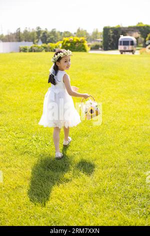 Cute flower girl playing on the grass Stock Photo - Alamy