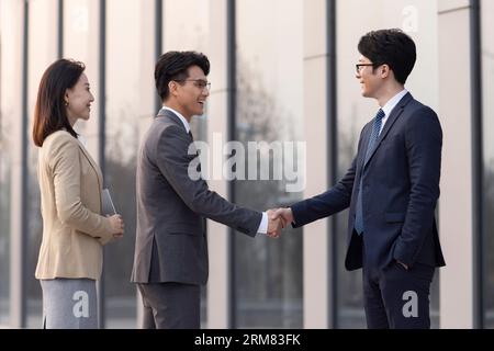 Confident business people shaking hands outdoors Stock Photo