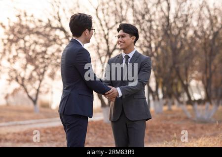 Confident businessmen shaking hands outdoors Stock Photo