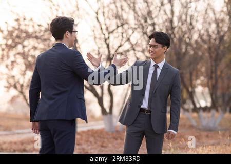 Confident businessmen greeting outdoors Stock Photo