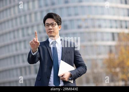 Confident businessman using finger to point Stock Photo