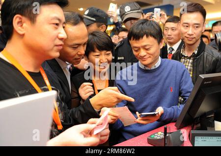 (140331) -- HANGZHOU, Nov. 16, 2013 (Xinhua) -- In this file photo taken on Nov. 16, 2013, Alibaba s CEO Jack Ma Yun (2nd R) is accompanied by Intime Retail Group Co. chairman Shen Guojun (2nd L) as he shops with Alibaba s online payment service Alipay at one of Intime s department stores in Hangzhou, capital of east China s Zhejiang Province. Chinese e-commerce giant Alibaba Group announced on Monday that it will pay 5.3 billion Hong Kong dollars (692 million U.S. dollars) to acquire shares of Hong Kong-listed department store operator Intime (Yintai) Retail Group Co. Under the two companies Stock Photo