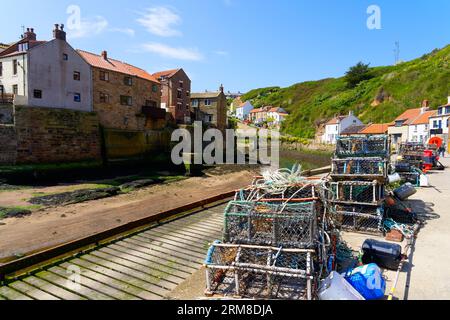 Lobster and crab pots stacked on the quayside in Staithes harbour in North Yorkshire. Stock Photo