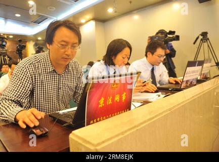 (140411) -- BEIJING, April 11, 2014 (Xinhua) -- Court staff members give a live webcast of the trial of Qin Zhijun, an alleged rumormonger, at the Chaoyang District People s Court in Beijing, capital of China, April 11, 2014. Qin Zhihui, known as Qinhuohuo in cyberspace, was accused of creating and spreading rumors about several Chinese celebrities including popular TV hostess Yang Lan, as well as China s former Ministry of Railways, via Sina Weibo, China s Twitter-like service, from December 2012 to August 2013, according to prosecutors. (Xinhua/Gong Lei) (lfj) CHINA-BEIJING-ALLEGED RUMORMONG Stock Photo