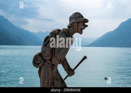 Wood sculpture of a hiker on the shores of Lake Brienz, Brienz, Canton of Bern, Switzerland. Stock Photo