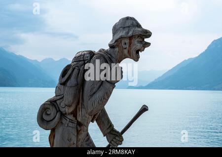 Wood sculpture of a hiker on the shores of Lake Brienz, Brienz, Canton of Bern, Switzerland. Stock Photo