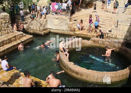 (140419) -- JERICHO, April 19, 2014 (Xinhua) -- Tourists play at the spring of Ein Fara, the upper spring of Wadi Kelt, in the Nahal Prat Nature Reserve near the West Bank city of Jericho on April 19, 2014. Wadi Kelt is a valley running west to east across the Judean desert in the West Bank, originating near Jerusalem and terminating near Jericho. (Xinhua/Mamoun Wazwaz) MIDEAST-JERICHO-WADI KELT SPRING-TOURISTS PUBLICATIONxNOTxINxCHN   Jericho April 19 2014 XINHUA tourists Play AT The Spring of a Fara The Upper Spring of Wadi Kelt in The Nahal Prat Nature Reserve Near The WEST Bank City of Jer Stock Photo