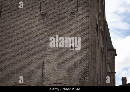 The smallest window in Brugge in the wall of the Gruuthusemuseum Stock Photo