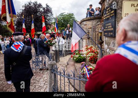 Pexonne, France. 27th Aug, 2023. Two men lay a wreath in front of the village church during a memorial ceremony for the invasion of Pexonne on August 27, 1944. In late August 1944, German soldiers invaded the French village of Pexonne and kidnapped dozens of villagers. The action was led by SS Hauptsturmführer Erich Otto Wenger. Now Wenger's grandchildren came to town for the first time to take part in a memorial service for the victims of the crime. Credit: Philipp von Ditfurth/dpa/Alamy Live News Stock Photo