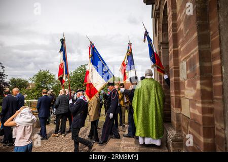 Pexonne, France. 27th Aug, 2023. Flag bearers leave the village church after a memorial service for the invasion of Pexonne on August 27, 1944. In late August 1944, German soldiers invaded the French village of Pexonne and kidnapped dozens of villagers. The action was led by SS Hauptsturmführer Erich Otto Wenger. Now Wenger's grandchildren came to the town for the first time to take part in a memorial service for the victims of the crime. Credit: Philipp von Ditfurth/dpa/Alamy Live News Stock Photo