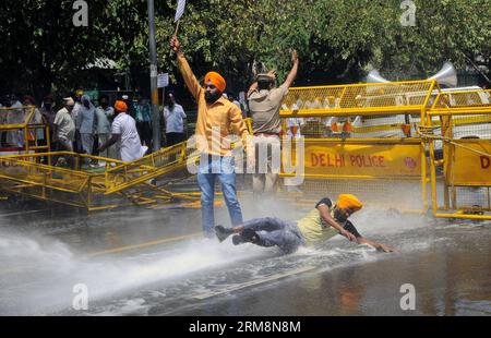 (140421) -- NEW DELHI, April 21, 2014 (Xinhua) -- Indian Sikh protesters face water canons during a protest against Congress party leader and former chief minister of Punjab state Amarinder Singh for his recent remarks on the country s 1984 anti-Sikh riots in New Delhi, India, April 21, 2014. Singh in a recent television interview said party leader Jagdish Tytler, one of the accused, had no role in the 1984 riots that killed more than 3,000 Sikhs. Top Congress party leaders have been accused of inciting mobs during the violence that followed the assassination of Prime Minister Indira Gandhi by Stock Photo